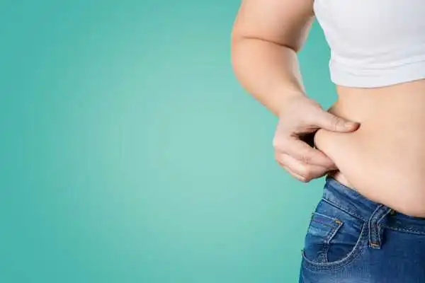 Image of woman pinching her love handles to show weight gain Dorchester